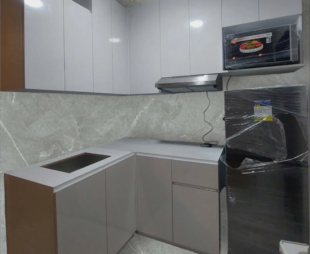 Compact modular kitchen with white cabinets and built-in appliances