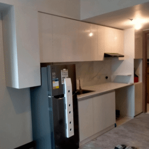 Custom modular kitchen cabinet with glossy white finish, marble backsplash, and modern built-in storage design.