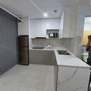 Custom modular kitchen cabinet with marble countertops, built-in storage, and modern L-shaped design.