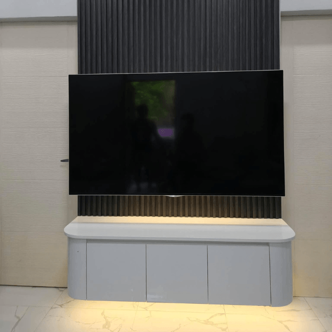 Modern custom TV console with LED backlit wood slat wall, floating cabinet, and built-in shelving.